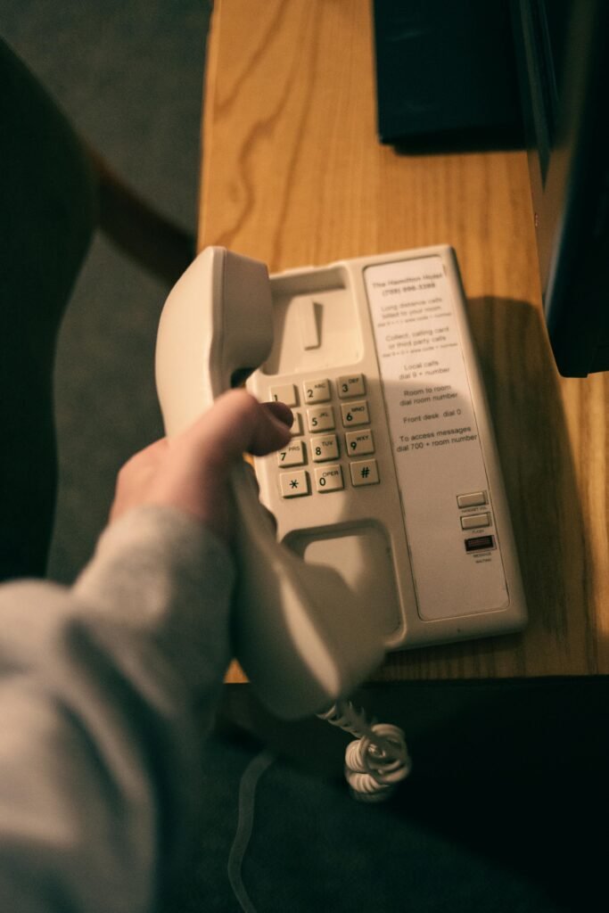 Close-up of a hand holding a vintage landline phone indoors.